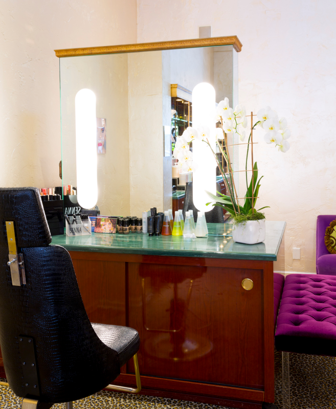 beverly hills studio makeup station with mirror and chair and products on counter